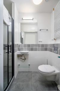 a white bathroom with a toilet and a sink at JESS INN Hostel Rondo Charles de Gaulle in Warsaw +8 photos