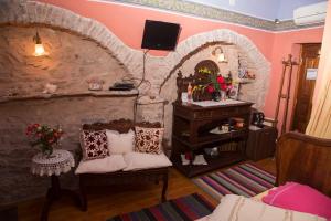 a living room with a chair and a stone wall at The Pounti in Pyrgi