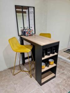 escritorio con 2 sillas amarillas y espejo en Chez Karine - Appartement, en Lédenon