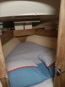 a bed on a boat with a wooden frame at Nuit insolite sur un bateau in Le Barcarès