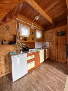 cocina con paredes de madera y techo de madera en Domki letniskowe Stary dąb, en Solina