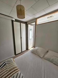 um quarto com uma grande cama branca e janelas em APPARTEMENT COTE D'OPALE em Boulogne-sur-Mer