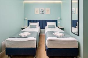 2 camas individuales en una habitación con espejo en JESS INN Hostel Rondo Charles de Gaulle, en Varsovia
