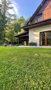 a house with a green lawn in front of it at Bórówka in Ujsoły