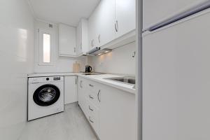 a white kitchen with a washing machine and a sink at Apartamento Fragata in Torrevieja +14 photos