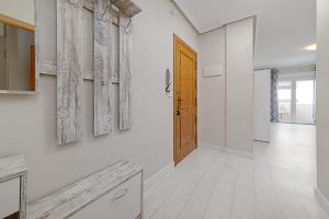 a hallway with a wooden door and white walls at Apartamento Fragata in Torrevieja