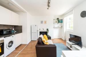 a living room with a couch and a tv at Super 1BD Flat minutes from Kings Cross Station in London
