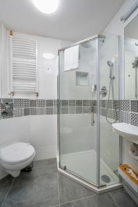 y baño con ducha, aseo y lavamanos. en JESS INN Hostel Rondo Charles de Gaulle en Varsovia