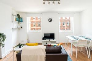 a living room with a couch and a table at Super 1BD Flat minutes from Kings Cross Station in London