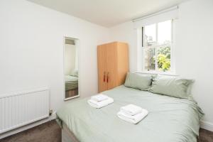 a bedroom with a bed with two towels on it at Super 1BD Flat minutes from Kings Cross Station in London