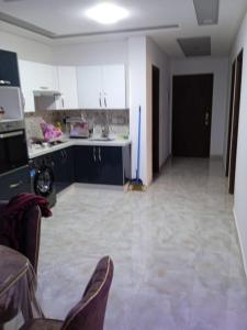 een woonkamer met een keuken met een fornuis en stoelen bij Appartement Saidia a 500 m de la plage in Saidia 