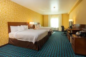 a hotel room with two beds and a desk and a television at Fairfield Inn & Suites by Marriott Bay City, Texas in Bay City