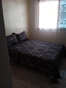 サイディアにあるAppartement Saidia a 500 m de la plage LOT Orange 3の窓とベッドカバーが備わるドミトリールームのベッド1台分です。