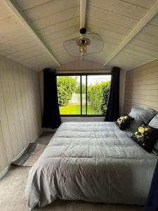 Saint-Sauveur-lès-BrayにあるChalet moderne au bord d'un lacのベッドルーム1室(大きなベッド1台、大きな窓付)