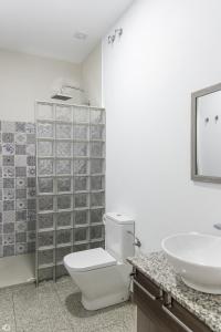 a bathroom with a toilet and a sink at Mesón Hostal La Cabaña in Medellín