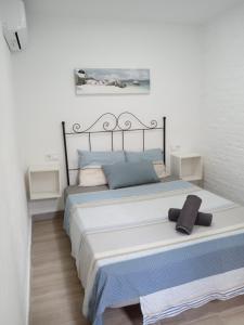 sypialnia z dużym łóżkiem z niebieskimi poduszkami w obiekcie Rooms Burjassot w mieście Burjasot