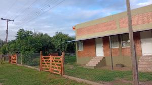 a brick house with a wooden fence in front of it at Los jacaranda in Cruz de Caña