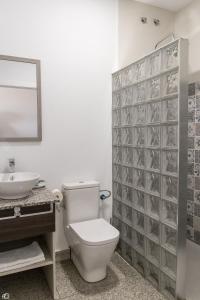 a bathroom with a toilet and a sink at Mesón Hostal La Cabaña in Medellín