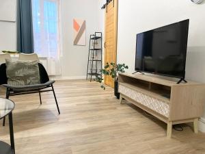 a living room with a flat screen tv on a entertainment center at Arina & Julien Dieppe in Dieppe