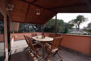 - une terrasse couverte avec une table et des chaises sur un balcon dans l'établissement Residence della Luna, à Porto Azzurro