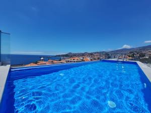 una grande piscina con vista sull'oceano di Apartments Madeira Barreirinha a Funchal