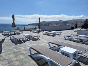 een groep stoelen en tafels en parasols op een patio bij Apartments Madeira Barreirinha in Funchal