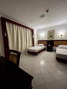 Un pat sau paturi într-o cameră la The New Garden Palace Hotel