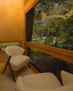 a room with a chair and a large window at Κonitsa Gefyri hotel in Konitsa