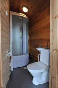 a wooden bathroom with a toilet and a sink at Hännilänsalmi Camping in Viitasaari
