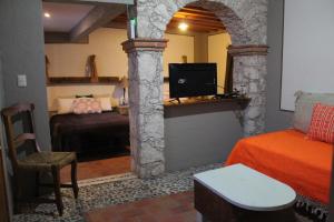 een kamer met een slaapkamer met een bed en een televisie bij Hotel Casa Caro in Bernal