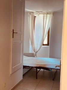Bett in einem Zimmer mit Fenster in der Unterkunft LOCATION TYPE T2 – APPARTEMENT – 4 COUCHAGES in Marseille
