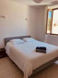 uma cama num quarto branco com uma almofada em LOCATION TYPE T2 – APPARTEMENT – 4 COUCHAGES em Marselha