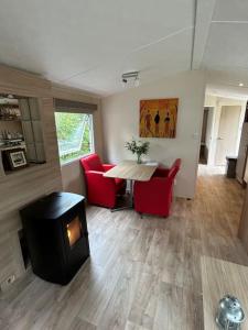 a living room with a fireplace and a table and chairs at Chalet De Bult 4 pers in De Bult