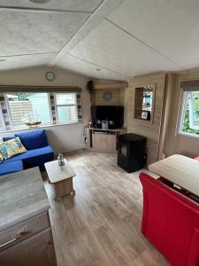 ein Wohnzimmer mit einem blauen Sofa und einem Tisch in der Unterkunft Chalet De Bult 4 pers in De Bult