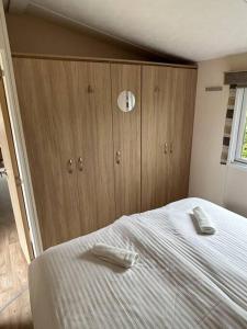 a bedroom with a bed and a wooden cabinet at Chalet De Bult 4 pers in De Bult