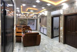 a living room with leather chairs and a table at The Pine Tree Chalet in Jerash