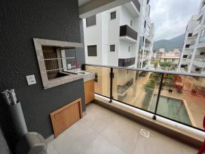 Cet appartement dispose d'un balcon offrant une vue sur un bâtiment. dans l'établissement Apartamento amplo e bem decorado, à Governador Celso Ramos
