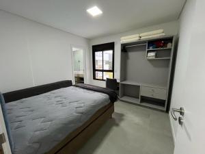 - une petite chambre avec un lit et une fenêtre dans l'établissement Apartamento amplo e bem decorado, à Governador Celso Ramos