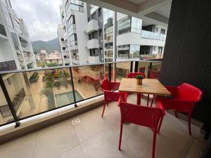 d'une table et de chaises sur un balcon avec vue sur un bâtiment. dans l'établissement Apartamento amplo e bem decorado, à Governador Celso Ramos