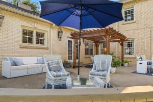 a patio with two chairs and an umbrella at Presidents House B & B in Plainview