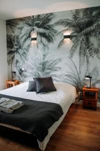 Schlafzimmer mit einem Bett und einem Wandbild von Palmen in der Unterkunft Les cabanes de l'océan, Villa confort proche plage sauvage in Messanges + 41 Fotos
