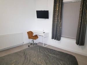 a room with a desk and a chair and a television at Kunda House Parkhill in Birmingham