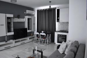 een woonkamer met een bank en een tafel bij Etalon Airport Apartments in Otopeni