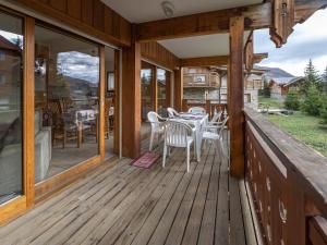 a wooden deck with a table and chairs on it at Appartement Huez, 2 pièces, 5 personnes - FR-1-645-17 in LʼHuez