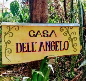 a sign that reads casa delle americoria attached to a tree at Casa Dell Angelo Apartamentos in Visconde De Maua