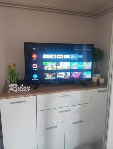 una TV a schermo piatto seduta sopra un armadio bianco di Villa Klaudija a Petrovaradin