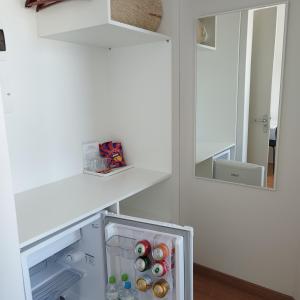 einen weißen Kühlschrank mit 2 Spiegeln in einem Zimmer in der Unterkunft Pousada dos Frades in Garibaldi