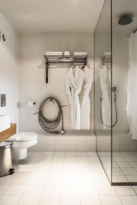 a bathroom with a shower stall with white robes at HOT_elarnia Hotel & Spa in Puszczykowo