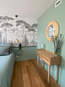 sypialnia z łóżkiem i drewnianym biurkiem w obiekcie La Musardise Guest House w mieście Berson