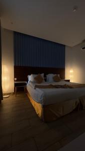 una habitación de hotel con una cama grande en una habitación en غرفة صالة بلكونة على الشاطئ - عوائل en Durat  Alarous